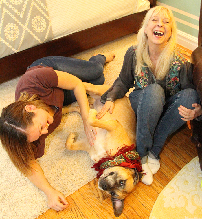 Christine sitting on floor surrounded by Gracie and Sam, a dog and a woman.